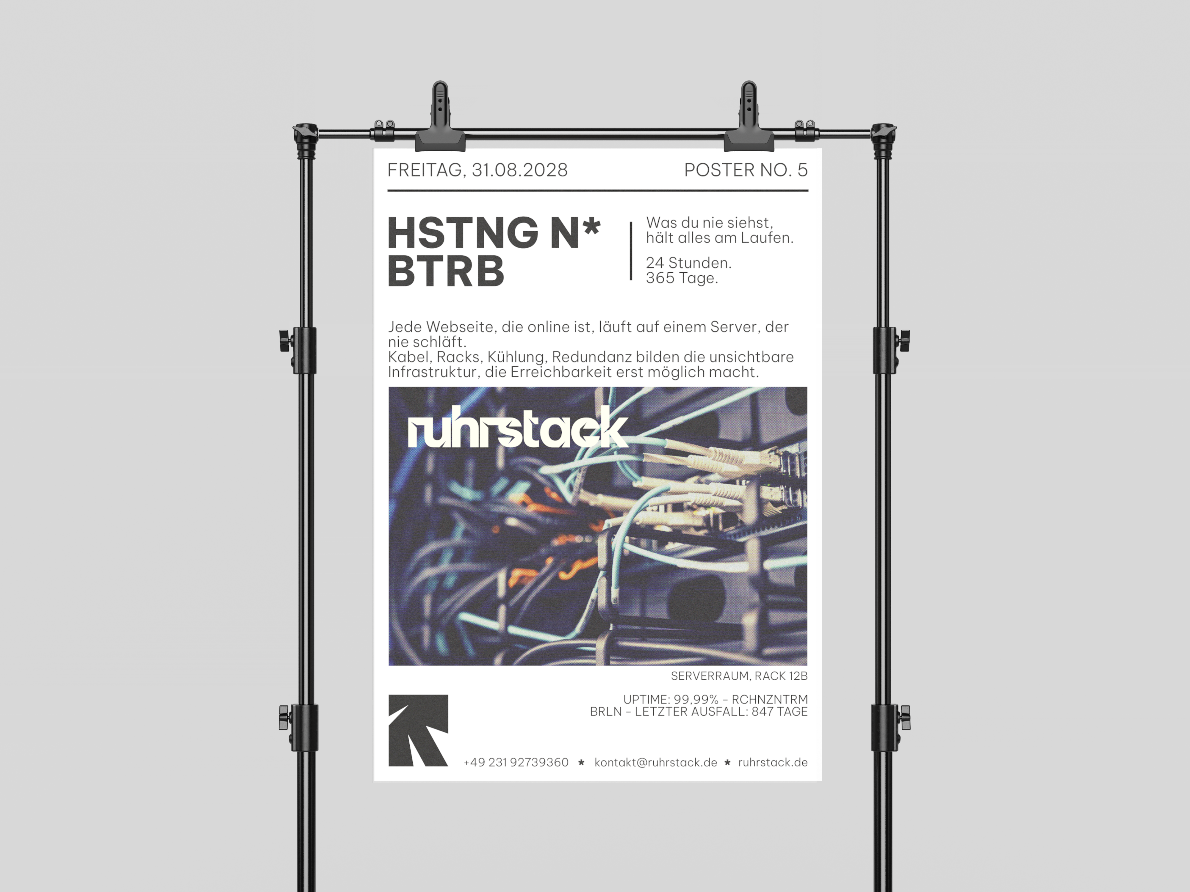 Ruhrstack Poster auf einem Ständer, darauf eine Aufnahme aus dem Serverraum mit Netzwerkkabeln und der Wortmarke ruhrstack