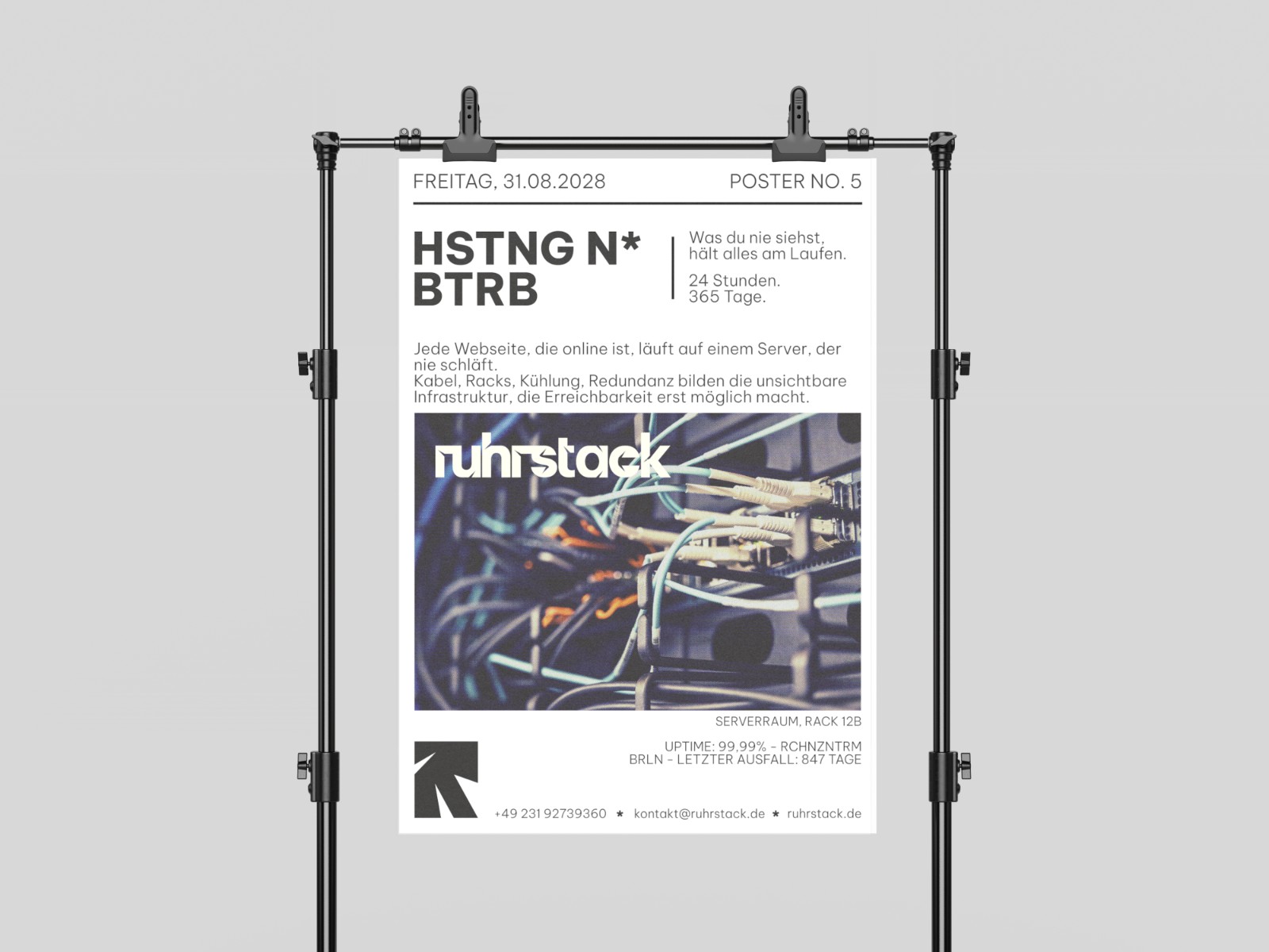 Ruhrstack Poster auf einem Ständer, darauf eine Aufnahme aus dem Serverraum mit Netzwerkkabeln und der Wortmarke ruhrstack